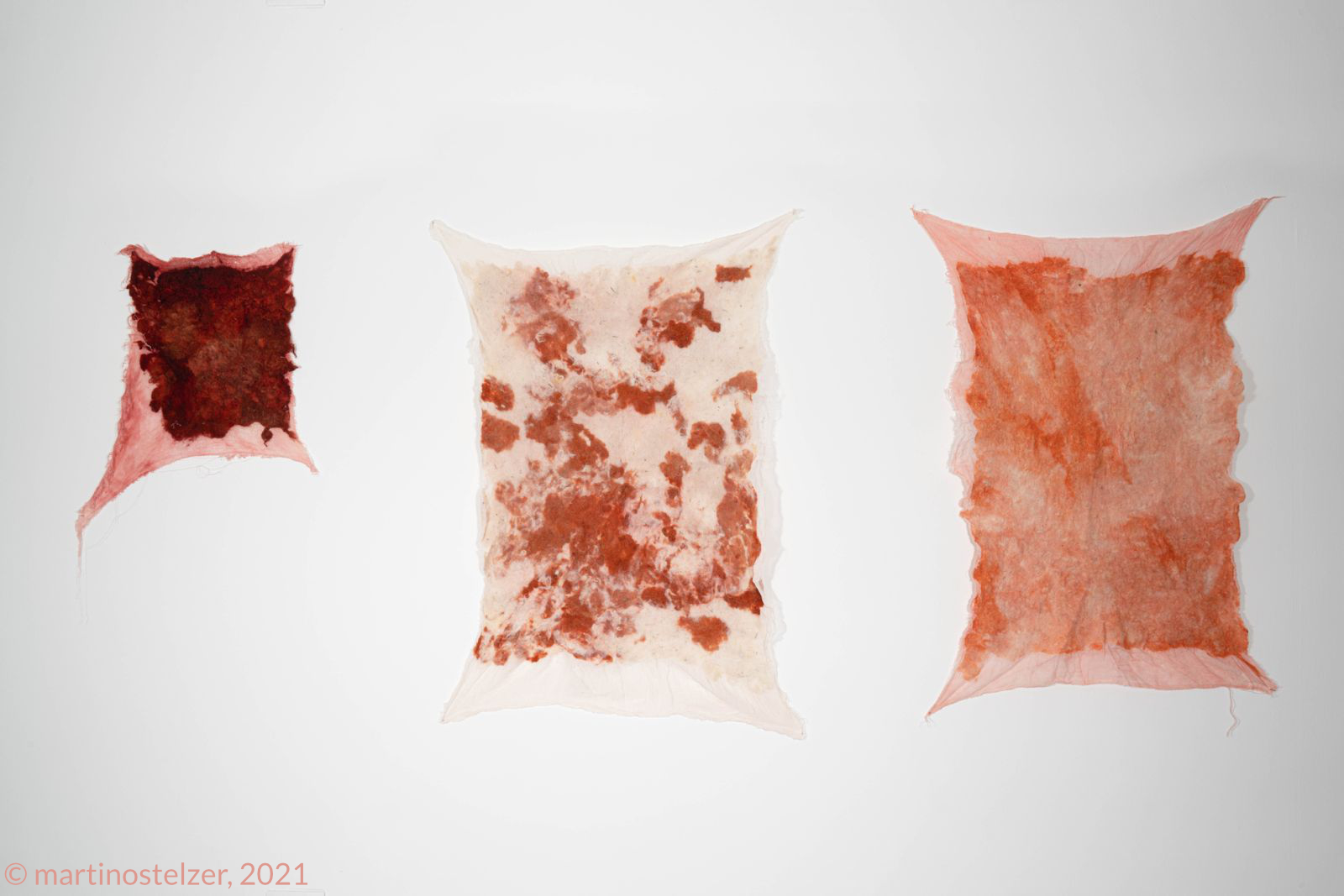 A trio of felted wool pieces by Theresa, showcasing natural red and earthy hues, hand-dyed using eco-friendly techniques.