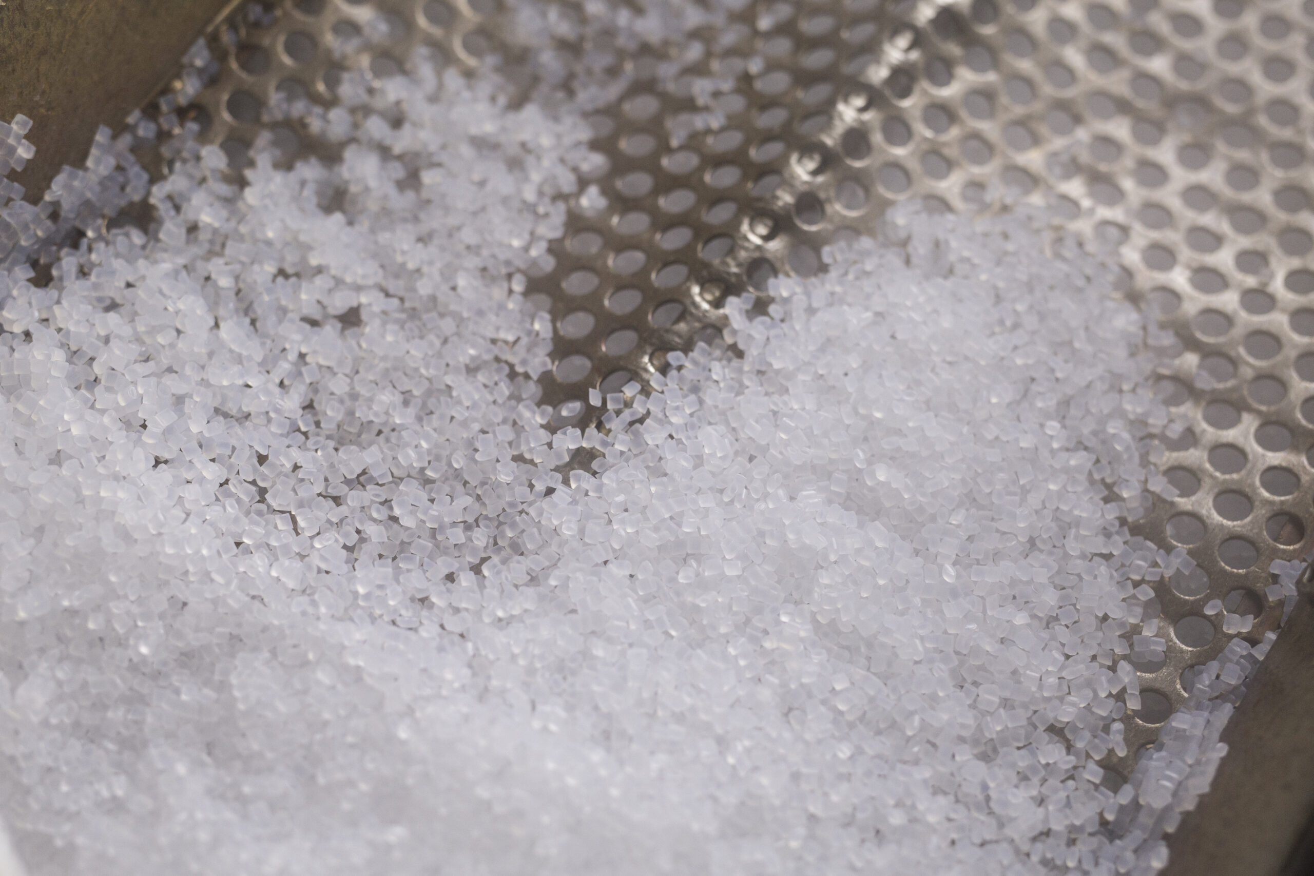 ECONYL® polymer granules – sustainable raw material made from regenerated fishing nets and nylon waste for eco-friendly swimwear production.