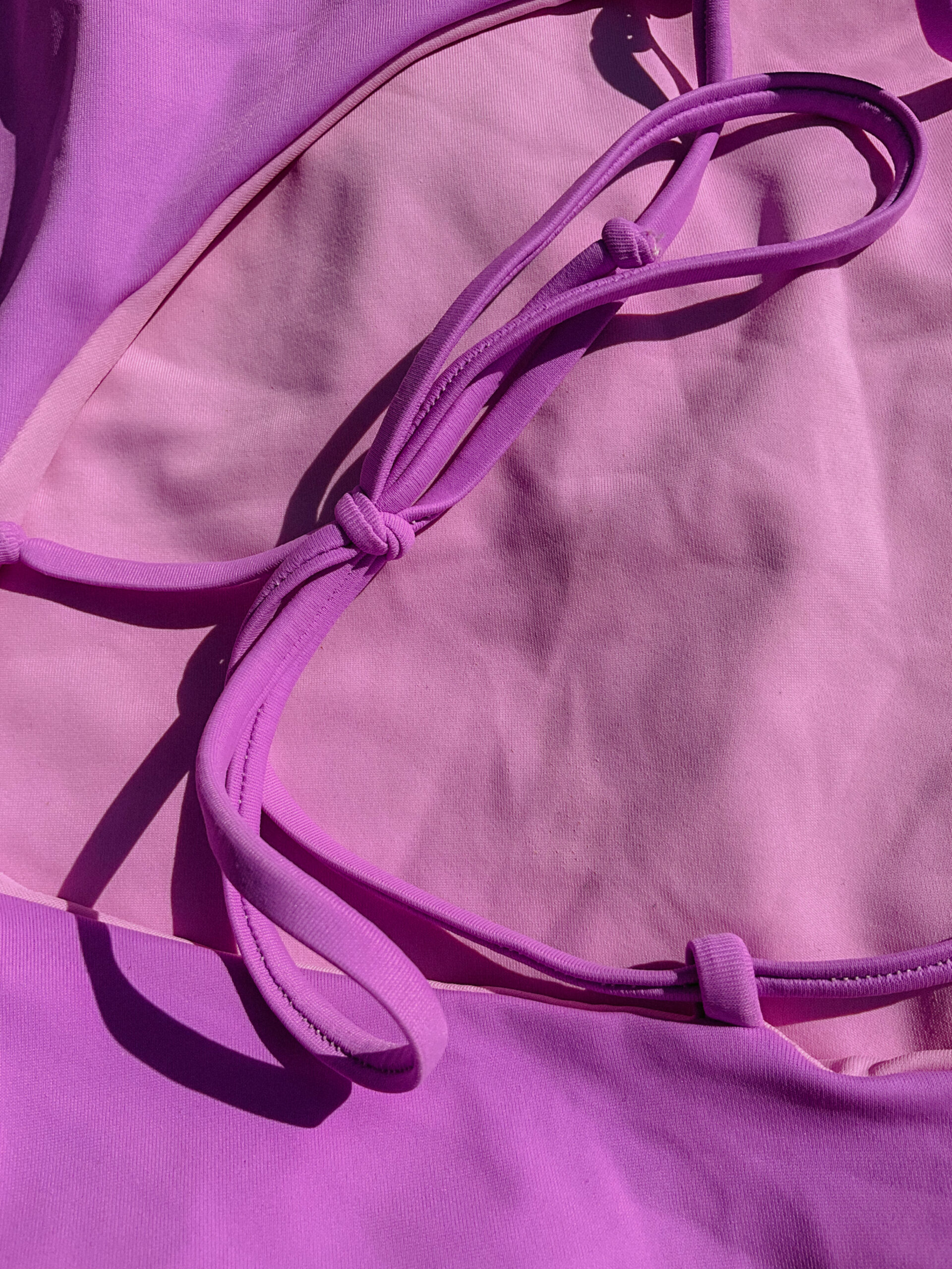 A detailed view of Cocou Conscious Couture’s Lilac bikini, featuring soft pink and purple strings.