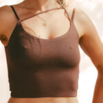 Close-up of the dark brown COCOU Alare crop top with thin crossed straps at the neckline.